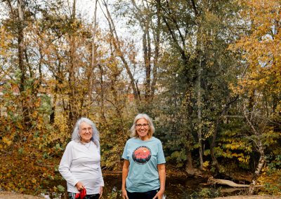 two women and dog at creek